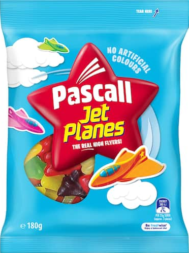Image of a plastic packet of "Pascall Jet Planes". The packet is mostly sky-blue, with clouds at the sides, and a large red star logo in the centre. A clear insert below and left of the star logo reveals a number of brightly coloured pieces of gelatine-based confectionary in the approximate shape of a delta-winged aircraft (such as a Dassault Mirage III). Below and to the right of the star logo is a cartoon representation of an aircraft similiar in shape to that of the confectionery. Readable text on the packaging includes "No Artificial Colours". "The Real High Flyers!" and "180g".