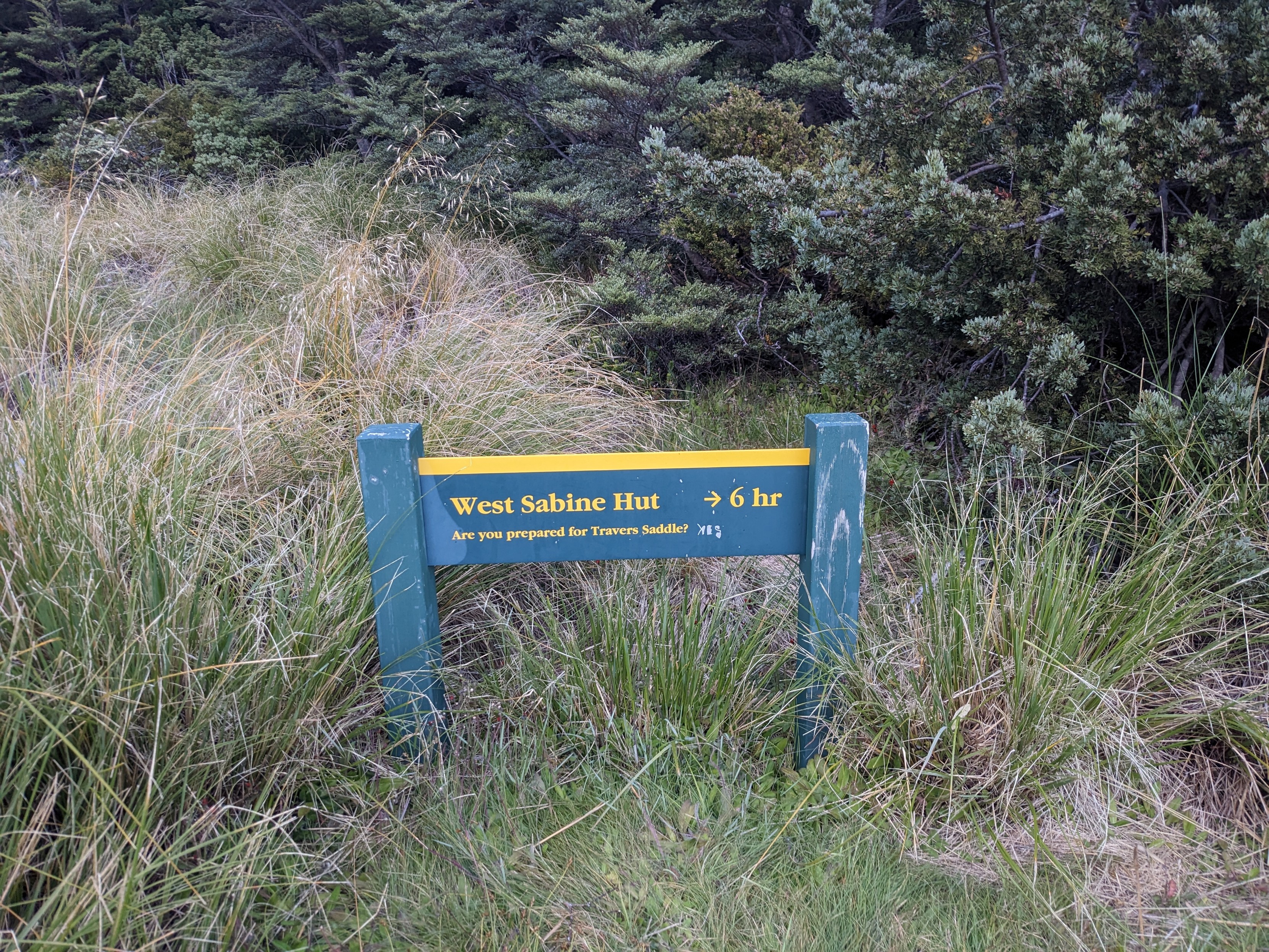 A sign indicating that the West Sabine Hut is 6h away, and asks "Are you prepared for Travers Saddle?".