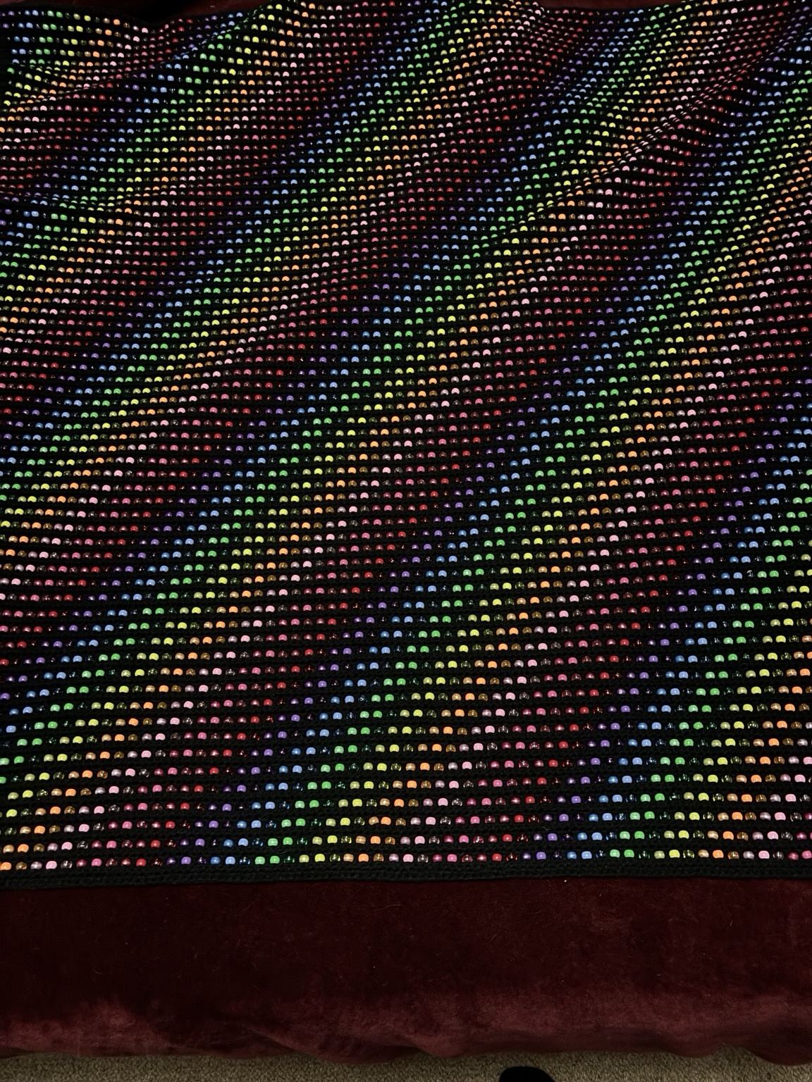Black yarn with 5,328 plastic rainbow beads. Measured approx 4 feet square.